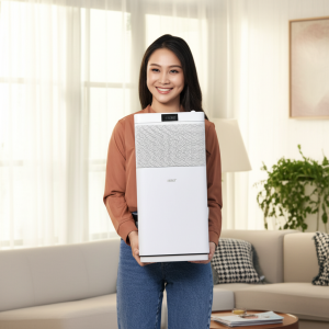 Seorang wanita tersenyum sambil memegang Acerpure Cool C3 di ruang tamu yang cerah dan modern.