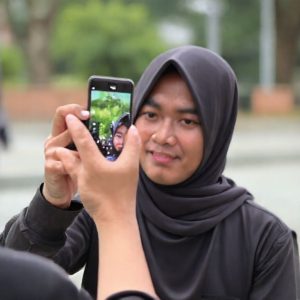 Seseorang sedang melakukan registrasi wajah menggunakan smartphone.