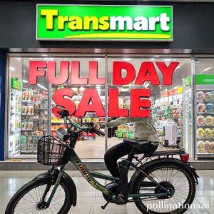 Tampilan rak sepeda listrik di Transmart dengan spanduk promosi 